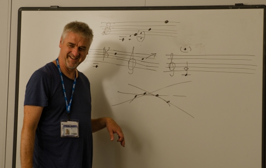 Man laughing with whiteboard with score behind